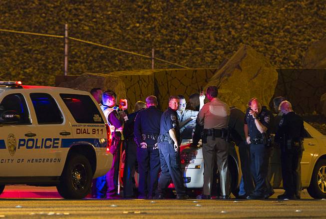 Law enforcement officers from Metro Police, Henderson Police and Nevada Highway Patrol confer near an accident site after a shooting victim was involved in an accident at the 1-215 eastbound off-ramp at Eastern Avenue Thursday, March 13, 2014. The driver, who had been shot multiple times, may have been shot at another location, police said.