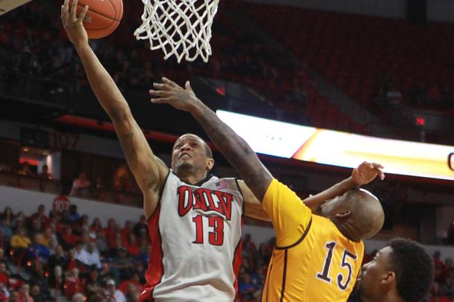 UNLV guard Bryce Dejean Jones drives to the basket while being defended by Wyoming guard Jerron Granberry during their Mountain West Conference tournament game Thursday, March 13, 2014 at the Thomas & Mack Center. UNLV won the game 71-67.