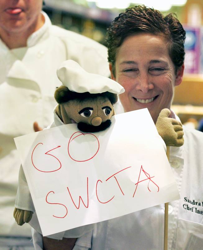 Culinary instructor Sandra Mallut and puppet Francois cheer on students from Southwest Career and Technical Academy as they compete in the Culinary Collision at the Whole Foods Market in Town Square on Thursday, March 13, 2014.