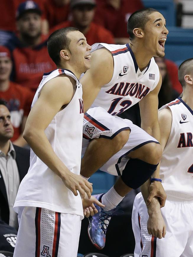 Arizona's Gabe York, left, and Nick Johnson (13) react to an Arizona basket late in the second half of an NCAA college basketball game in the quarterfinals of the Pac-12 conference tournament against Utah, Thursday, March 13, 2014, in Las Vegas. Arizona won 71-39.
