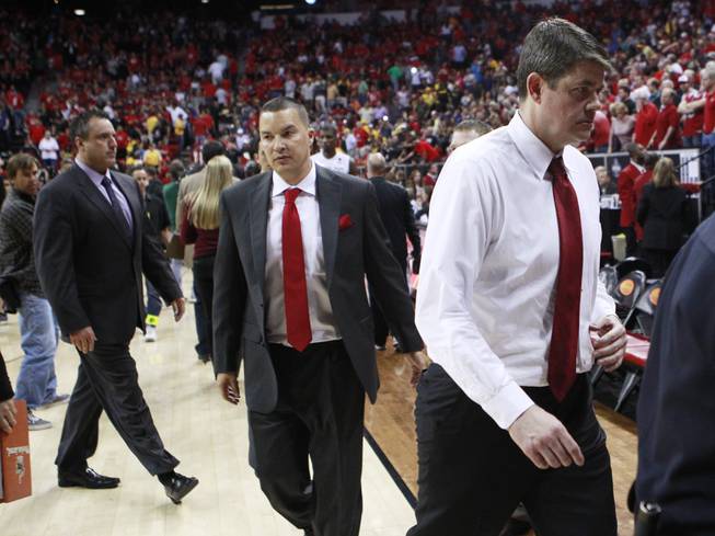 UNLV associate head coach Heath Schroyer, San Diego State assistant coach Justin Hutson and UNLV head coach Dave Rice exit the court after the Aztecs beat the Rebels 59-51 in their Mountain West Conference semifinal game Friday, March 14, 2014.