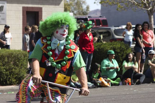 A member of the Zelzah Shrine Clowns ride by on his bike during the annual St. Patrick's Day parade in Henderson Saturday, March 15, 2014.