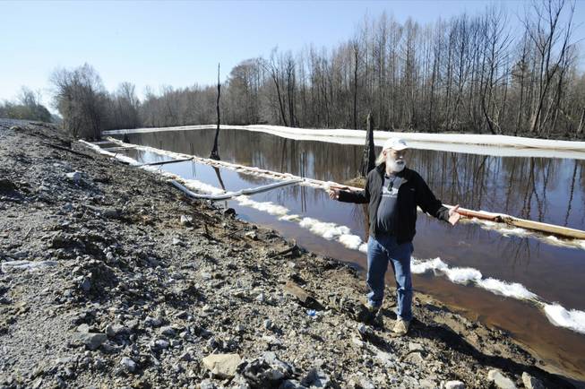 John Wathen, an environmentalist with the Waterkeeper Alliance, gestures at the site of a train derailment and oil spill near Aliceville, Ala., on Wednesday, May 5, 2014. Environmental regulators say cleanup and containment work is continuing at the site, but critics contend the accident and others show the danger of transporting large amounts of oil in tanker trains.