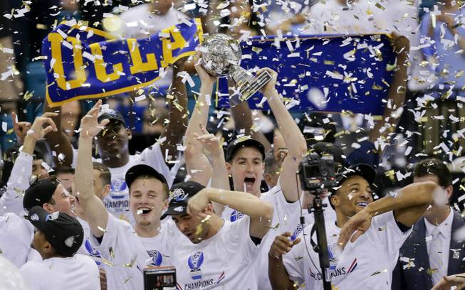 UCLA players celebrate with the championship trophy after beating Arizona 75-71 in the championship game of the NCAA Pac-12 conference college basketball tournament, Saturday, March 15, 2014, in Las Vegas.