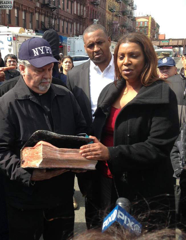 Rick Del Rio, pastor of Abounding Grace church in Manhattan, and New York City Public Advocate Letitia James, display a damaged but intact Bible they said was recovered in the rubble of the Spanish Christian Church, Saturday, March 15, 2014 in New York. The church was in one of the buildings destroyed in the March 12 gas explosion that leveled two building and killed eight people.