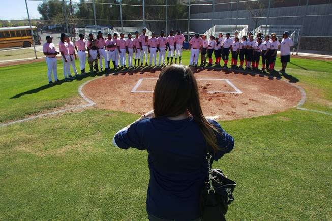 Kelly Webb from the Candlelighters takes a photo of the Canyon Springs baseball and softball teams before  their game against Western Wednesday, March 19, 2014. The Pioneers wore pink jerseys for the game for cancer awareness and to honor parents of two of the players who died from cancer in the past year.