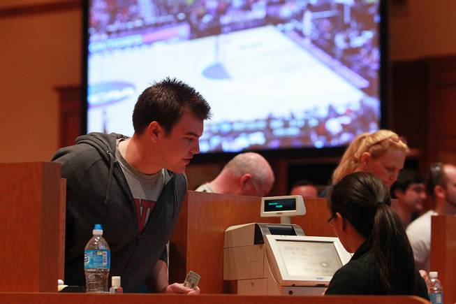 Bettors make their wagers in a ballroom during the second round of the NCAA basketball tournament Thursday, March 20, 2014, at South Point.
