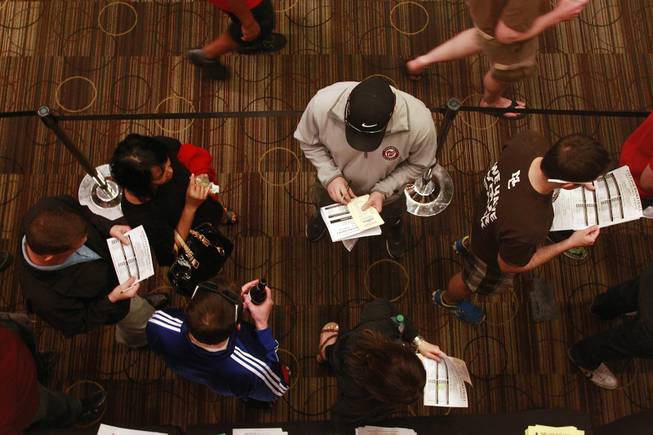Bettors stand in line at a satellite sports betting window at the LVH during the second round of the NCAA basketball tournament Thursday, March 20, 2014.