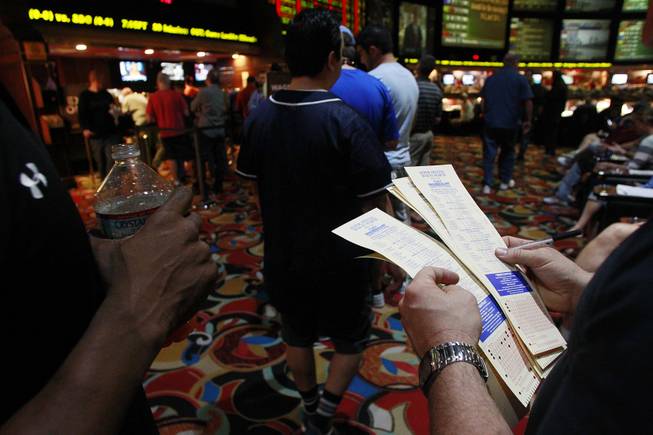 Bettors stand in line to make their wagers at the LVH sports book during the second round of the NCAA basketball tournament Thursday, March 20, 2014.
