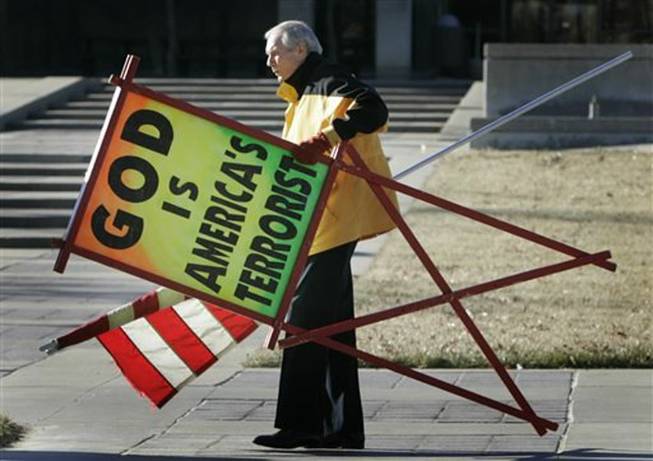 In this July 1, 2007, file photo, the Rev. Fred Phelps Sr. prepares to protest outside the Kansas Statehouse in Topeka, Kan. Phelps, the founder of the Kansas church known for anti-gay protests and pickets at military funerals, died Thursday, March 20, 2014. He was 84.