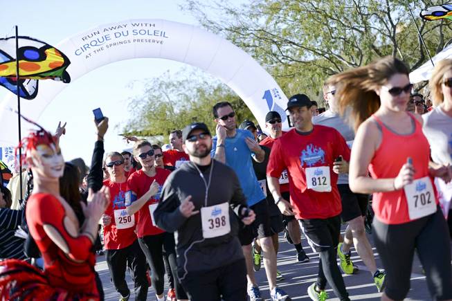 Participants cross the starting line at the onset of the Run Away with Cirque du Soleil 5K Run and One-Mile Fun Walk at the Springs Preserve on Saturday, March 15, 2014.