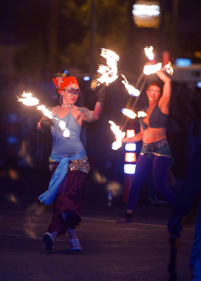 Members of the Flameology dance troupe perform with fire before the burning of the Life Cube, an interactive community art installation, in downtown Las Vegas, Friday March 21, 2014. The Life Cube, a creation of artist Scott Cohen, was a 24-by-24-foot plywood cube, painted by artists and filled with notes from thousands of people.