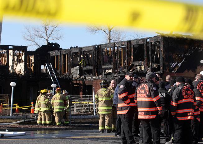 Firefighters investigate a fatal fire at the Mariner's Cove Hotel in Point Pleasant Beach, N.J. on Friday, March 21, 2014.
