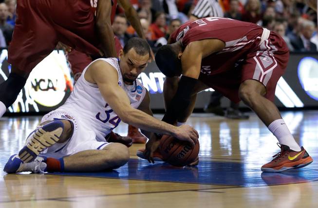 Kansas' Perry Ellis, left, and Eastern Kentucky's Corey Walden fight over a loose ball during the first half of a second-round game in the NCAA college basketball tournament Friday, March 21, 2014, in St. Louis.