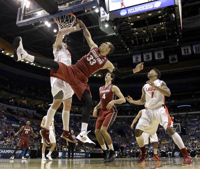 New Mexico's Cameron Bairstow, left, blocks a shot by Stanford's Dwight Powell (33) during the first half of a second-round game in the NCAA college basketball tournament, Friday, March 21, 2014, in St. Louis.
