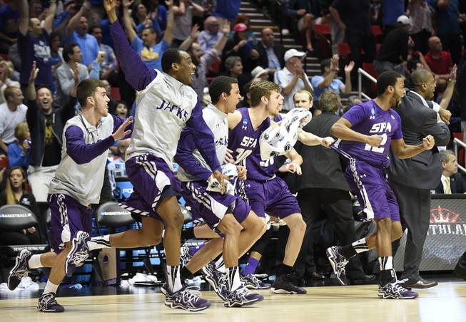 Stephen F. Austin players run onto the court as they beat Virginia Commonwealth 77-75 in overtime in a second-round game in the NCAA college basketball tournament Friday, March 21, 2014, in San Diego. 