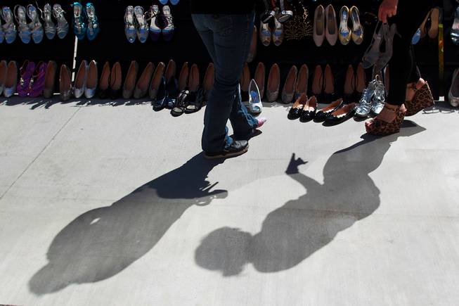 Aubrie Pagano and Felicia Conley cast shadows as they look for a pair of shoes for Felicia during Las Vegas Prom Closet's "Operation Glass Slipper" Saturday, March 22, 2014.