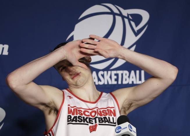 Wisconsin forward Sam Dekker reacts to the lights as he arrives at a news conference for the third-round game of the NCAA college basketball tournament Friday, March 21, 2014, in Milwaukee. Wisconsin plays Oregon on Saturday.
