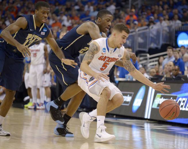 Florida guard Scottie Wilbekin (5) forces Pittsburgh forward Lamar Patterson (21) to turn over the ball as Pittsburgh guard Josh Newkirk (13) closes in during the second half in a third-round game in the NCAA college basketball tournament Saturday, March 22, 2014, in Orlando, Fla.