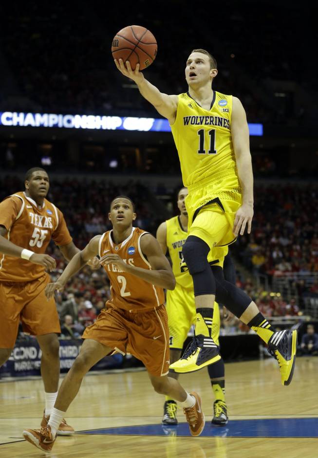 Michigan guard Nik Stauskas drives to the basket during the first half of a third-round game against Texas in the NCAA college basketball tournament Saturday, March 22, 2014, in Milwaukee.