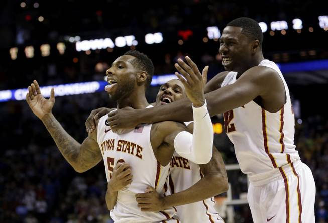 Iowa State's DeAndre Kane (50) is grabbed by teammates Monte Morris, center, and Daniel Edozie, right, after making the game-winning basket against North Carolina during the second half of a third-round game in the NCAA college basketball tournament Sunday, March 23, 2014, in San Antonio. Iowa State won 85-83.