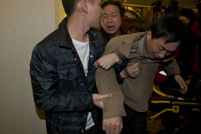 Relatives of a Chinese passenger aboard the Malaysia Airlines MH370, grieve after being told the latest update in Beijing, China, Monday, March 24, 2014. 