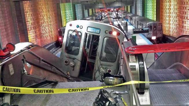A Chicago Transit Authority train car rests on an escalator at the O'Hare Airport station after it derailed early Monday, March 24, 2014, in Chicago. More than 30 people were injured after the train "climbed over the last stop, jumped up on the sidewalk and then went up the stairs and escalator," according to Chicago Fire Commissioner Jose Santiago.