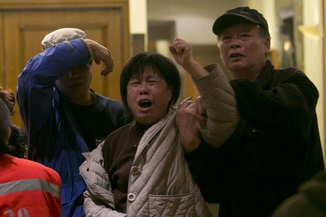 A relative of one of the Chinese passengers aboard missing Malaysia Airlines MH370 grieves after being told of the latest news in Beijing, China, Monday, March 24, 2014. A new analysis of satellite data indicates the missing Malaysia Airlines plane crashed into a remote corner of the Indian Ocean, Malaysian Prime Minister Najib Razak said Monday.