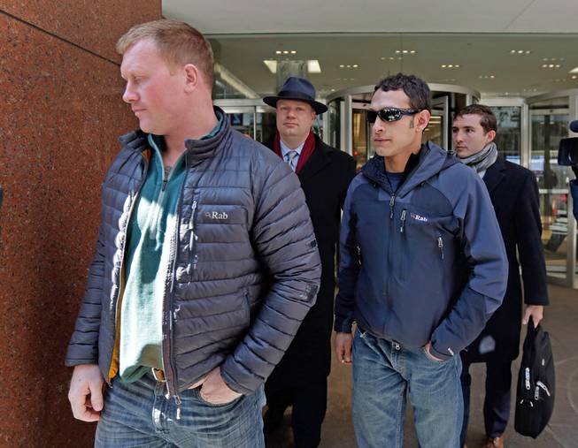 James Brady and Andrew Rossig, foreground left and right, two parachutists who jumped from One World Trader Center in September 2013, are accompanied by attorneys Timothy Parlatore, background left and Andrew Mancilla, to surrender to police, in New York, Monday, March 24, 2014. 