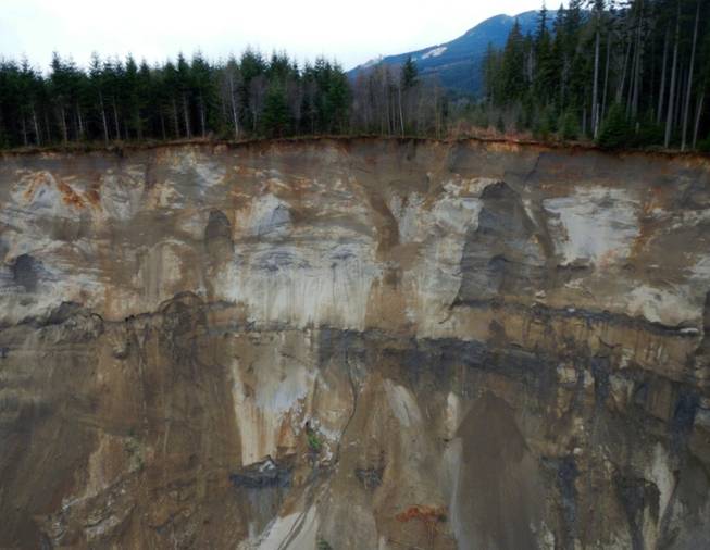 This March 23, 2014 photo, made available by the Washington State Dept of Transportation shows a view of the damage from Saturday's mudslide near Oso, Wash. At least eight people were killed in the 1-square-mile slide that hit in a rural area about 55 miles northeast of Seattle on Saturday. Several people also were critically injured, and about 30 homes were destroyed.