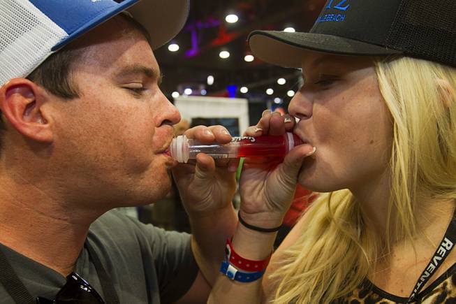 William Cole and his girlfriend Kelsey Mackenzie try out the "Suck & Blow" jello shot during the Nightclub & Bar Convention and Trade Show at the Las Vegas Convention Center Wednesday March 26, 2014.