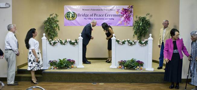Brian Greenspun bows to Nakia Woodson as they participate in a Bridge of Peace Ceremony of Reconciliation and Healing at the Elks Lodge on Wednesday, March 26, 2014. It was a highlight during A Moulin Rouge Affair sponsored by the Harrison House.