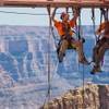 In this Tuesday, March, 25, 2014, photo provided by Abseilon USA via AZ Photos, technicians dangle from a series of ropes before polishing the underside glass at Grand Canyon Skywalk in Hualapai Reservation, Ariz. The more than 40 panes of glass underneath the horseshoe-shaped bridge on the Hualapai reservation aren’t easily accessible. The structure juts out 70 feet from the edge of the Grand Canyon, offering visitors a view of the Colorado River 4,000 feet below.