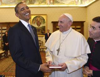 Pope Francis and President Barack Obama smile as they exchange gifts, at the Vatican Thursday, March 27, 2014. 