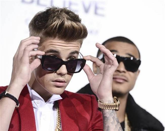 In this Dec. 18, 2013, photo, singer Justin Bieber arrives at the premiere of the feature film "Justin Bieber's Believe" at Regal Cinemas L.A. Live in Los Angeles. A security guard for Bieber was indicted on Tuesday, Feb. 25, 2014, for allegedly stealing a photographer's camera.