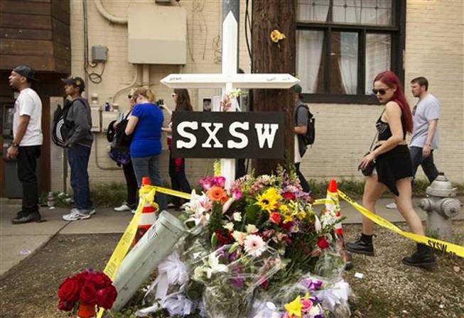 In this March 15, 2014, file photo, a cross and flowers are outside The Mohawk in Austin, Texas, as a memorial to the people who died after being struck by a drunken driving suspect during the South By Southwest festival. On Thursday, March 27, 2014, police said a fourth person, DeAndre Tatum, had died of injuries in the crash.