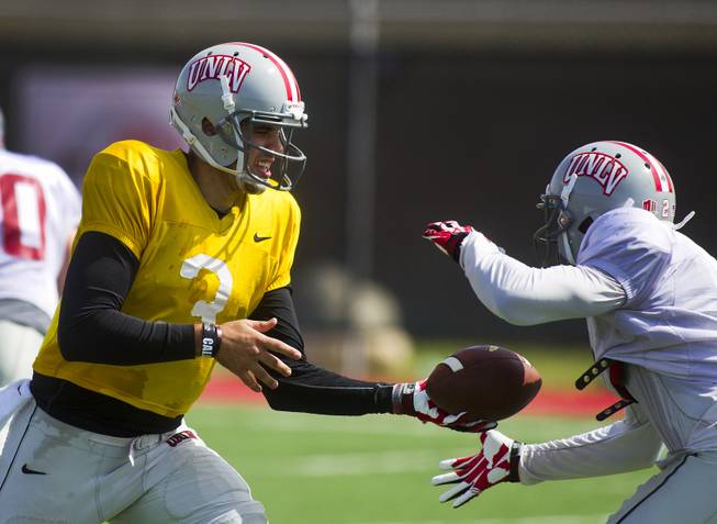 UNLV QB Nick Sherry hands off the ball to RB Adonis Smith during practice at Rebel Park on Friday, March 28, 2014.