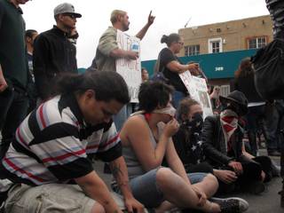 Protesters sit in downtown Albuquerque, N.M. during a rally Sunday March 30, 2014,  against a recent police shootings.