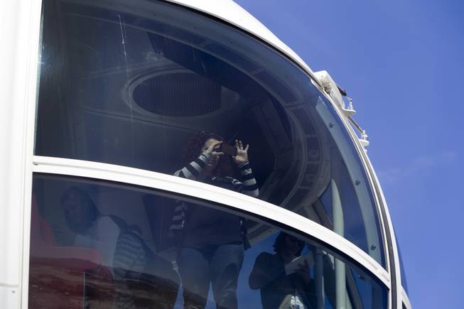 A woman takes a photo from a cabin during a ride on the 550-foot-tall High Roller observation wheel Monday, March 31, 2014. The observation wheel, the tallest in the world, is part of the Linq project, a $550 million development by Caesars Entertainment Corp.