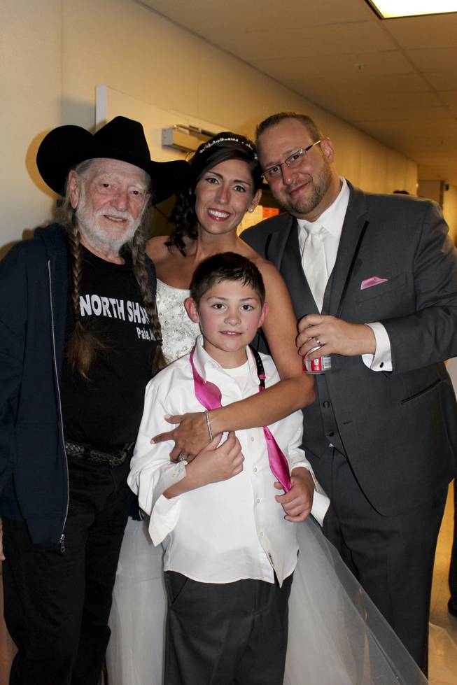 Willie Nelson poses with newlyweds who were having their wedding reception concurrent to his concert at The Westin at Lake Las Vegas Monday, March 31, 2014.