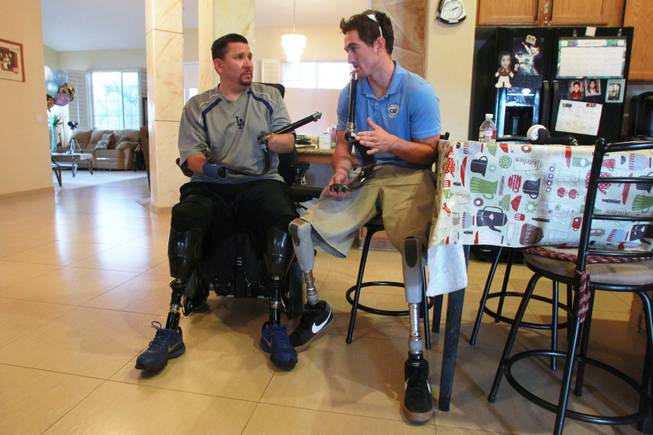 Amputee Eddie Garcia talks with Rudy Garcia-Tolson from the Challenged Athletes Foundation about the new prosthetics he will be receiving Wednesday, April 2, 2014.