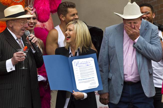 Olivia Newton-John laughs at a joke by Las Vegas Host Committee Chairman Oscar Goodman during her official arrival with a welcome event at the Flamingo to begin her residency “Summer Nights” on Wednesday, April 2, 2014.