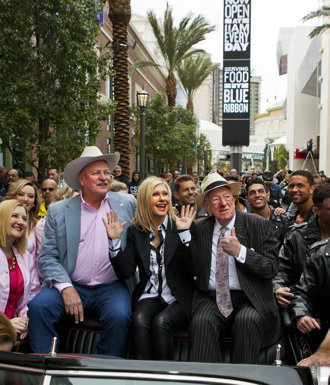 Clark County Commissioner Tom Collins, Olivia Newton-John and Las Vegas Host Committee Chairman Oscar Goodman enjoy the view from a restored T-Bird at the Linq on Wednesday, April 2, 2014.