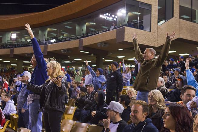Fans attempt to get the attention of people throwing out free T-shirts during the 51's season opener against the Fresno Grizzlies Thursday, April 3, 2014.