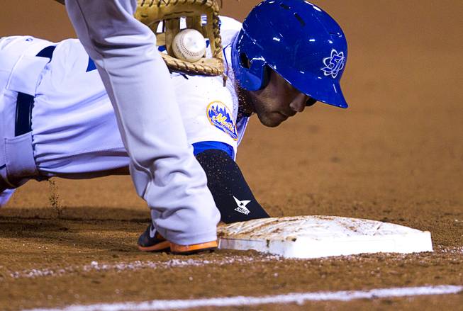 Las Vegas 51's Anthony Seratelli makes it safely back to first during a pickoff attempt in the 51's season opener against the Fresno Grizzlies Thursday, April 3, 2014.