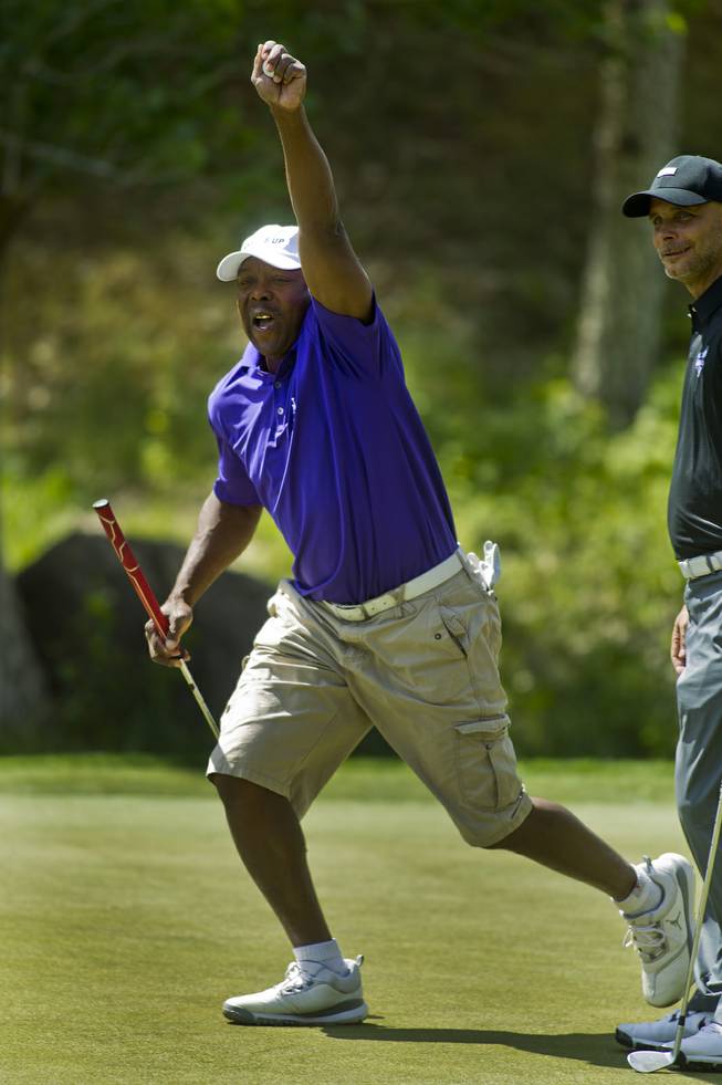 Former MLB player Vince Coleman celebrates a long putt with teammates during opening day play of the Michael Jordan Celebrity Invitational at Shadow Creek Golf Course on Thursday, April 3, 2014.