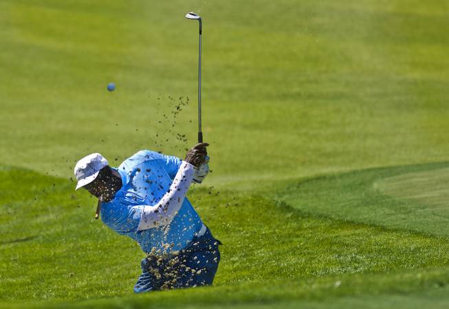 Former NBA star Michael Jordan digs the ball out of the sand during opening day play of the Michael Jordan Celebrity Invitational at Shadow Creek Golf Course on Thursday, April 3, 2014.