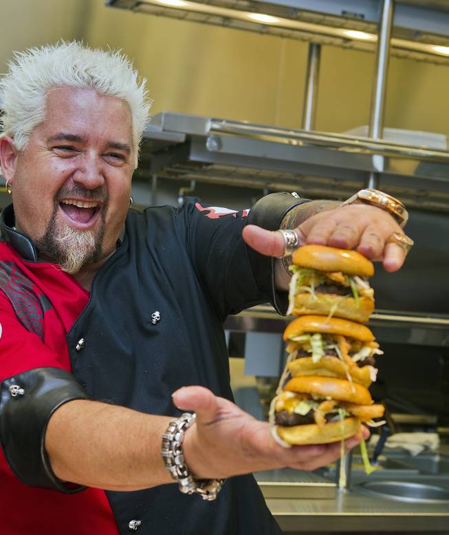 Guy Fieri shows off his signature Mac & Cheese Bacon Burger from the new kitchen of Guy Fieri’s Vegas Kitchen & Bar on Friday, April 4, 2014, at the Quad. The restaurant is set to open this month.