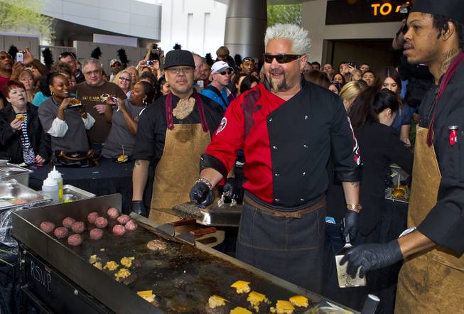 Guy Fieri works a patio grill at The Quad helping to serve burgers to fans outside his first Las Vegas restaurant, Guy Fieri's Vegas Kitchen & Bar on Friday, April 4, 2014.