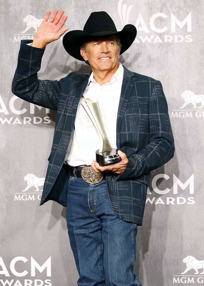 George Strait, winner of the Entertainer of the Year award, waves as he leaves the photo room during the 49th Academy of Country Music Awards at the MGM Grand Garden Arena Sunday, April 6, 2014.